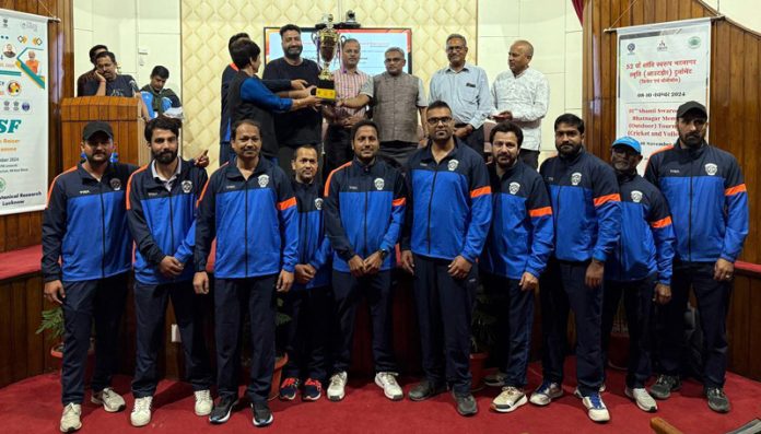 Dignitaries presenting trophy to winning team while posing for group photograph.