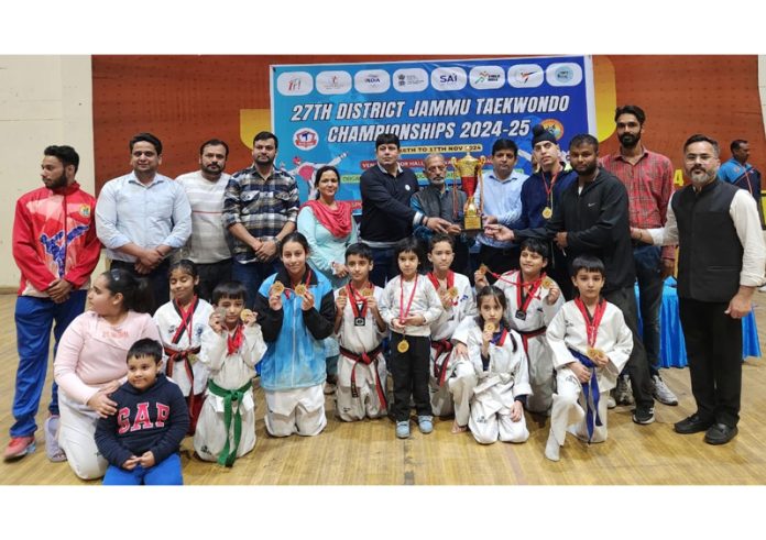 Taekwondo players posing along with dignitaries during prize distribution ceremony.