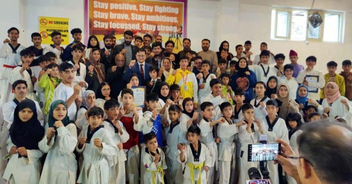 Dignitaries posing along with young Taekwondo players at Baramulla.