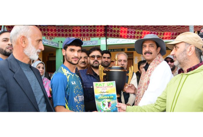 Minister for YS&S, Satish Sharma presenting trophy to winning team captain at Safapora on Sunday.