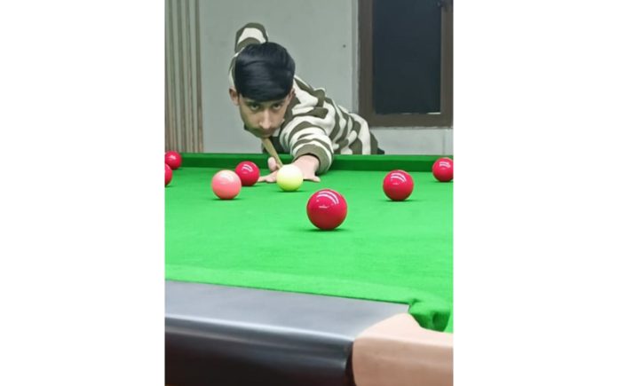 Snooker player Fuzail Bhat displaying his skills during a match at Srinagar.