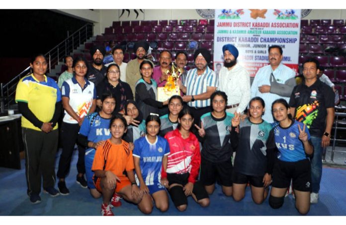 Dignitaries posing along with winning team members and trophy.