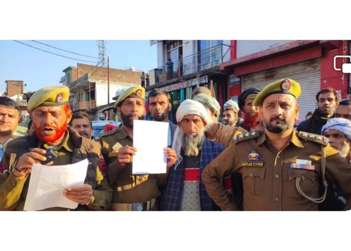 Police with drum beaters issuing warning to 14 proclaimed offenders to surrender within 30 days at Koranka town in Rajouri on Friday.