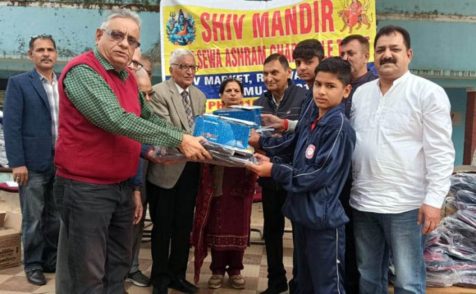 Shiv Mandir Sant Seva Ashram Charitable Trust members distributing essential items among the needy students in Akhnoor on Saturday.