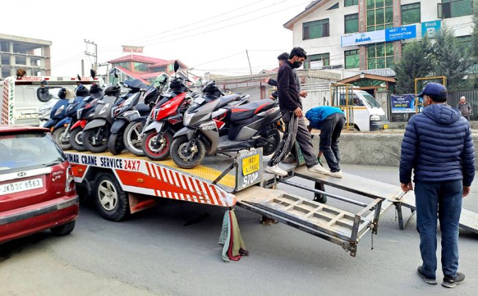 Traffic police in action against underage two-wheeler riders in Srinagar on Friday. —Excelsior/Shakeel