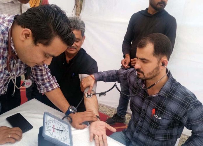 A Doctor examining a driver during free health check up camp organized in Jammu on Monday.