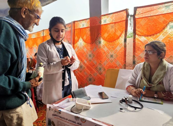 A doctor explaining dose to an elderly patient during a medical camp at a remote village in Jammu on Saturday.