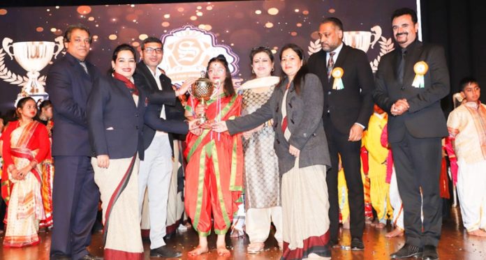 Chief guest presenting trophy to a student during Annual Day event.