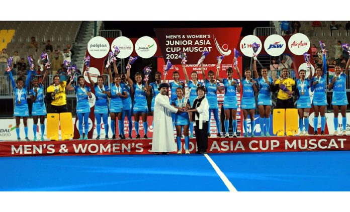 Junior Women’s Hockey team posing for group photograph along with trophy.