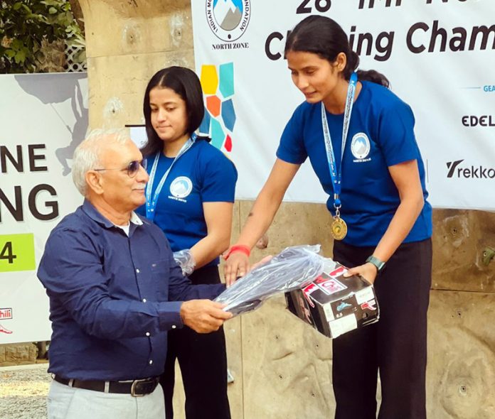 Shivani Charak, top performer receiving medal and prizes from a dignitary.