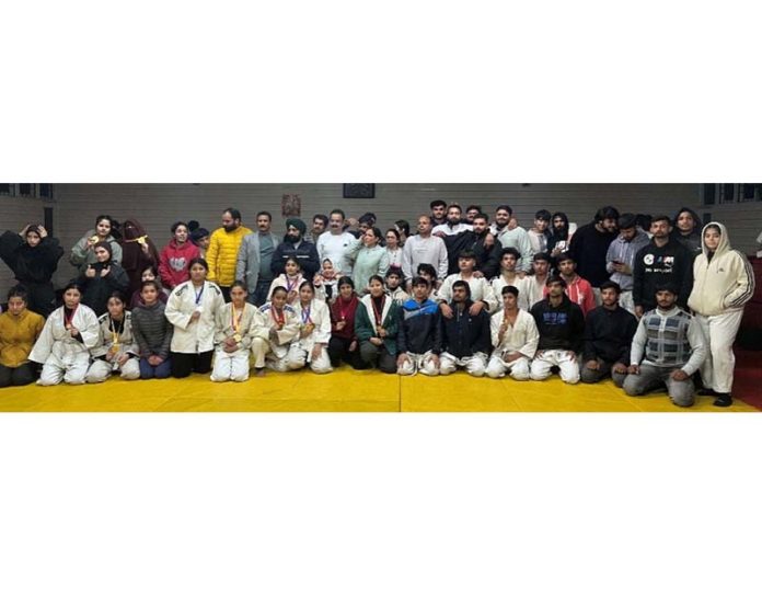 Judokas posing for group photograph along with medals.