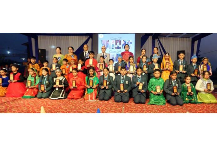 Students posing along with mementos and dignitaries during a cultural event.