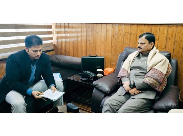 Minister Javed Rana interacting with a senior officer on Tuesday.