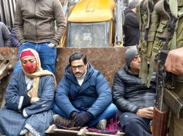 MLA Ahsan Pardesi sits on a JCB to oppose demolition drive in Sonawar area of Srinagar. - Excelsior/Shakeel