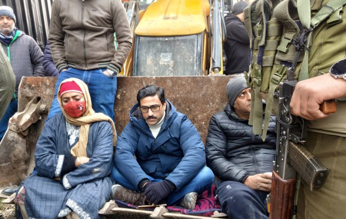 MLA Ahsan Pardesi sits on a JCB to oppose demolition drive in Sonawar area of Srinagar. - Excelsior/Shakeel