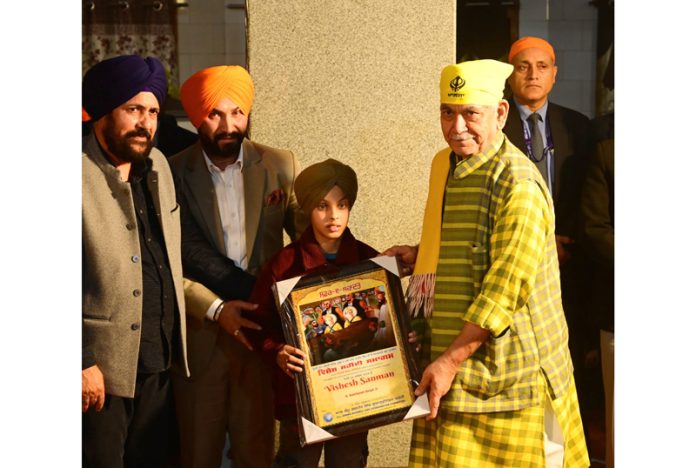 LG felicitating a child of Sikh community on Thursday.