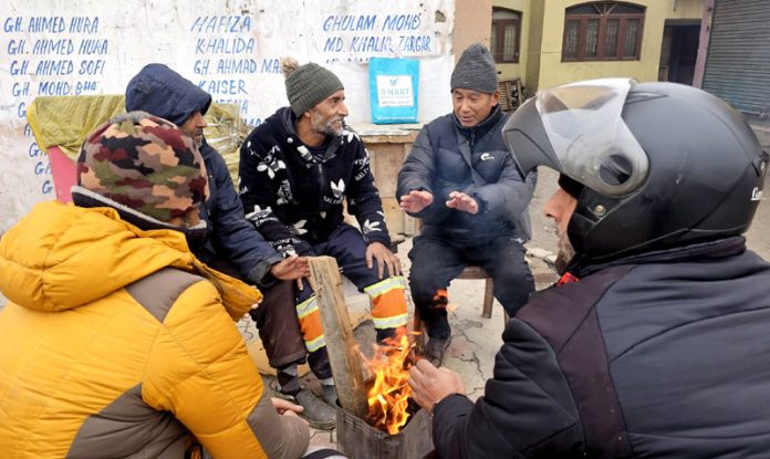 A group of men warming themselves by the roadside in Srinagar on Saturday, as cold wave conditions prevail across Kashmir. -Excelsior/Shakeel