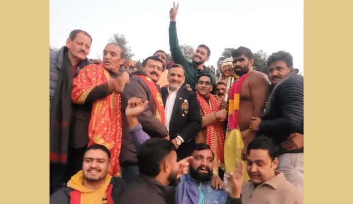 A winner posing along with dignitaries.