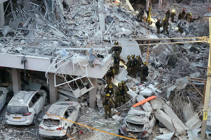 Responders work amid building rubble following a strike by an Iranian missile in the Israeli city of Bat Yam on Sunday. Responders work amid building rubble following a strike by an Iranian missile in the Israeli city of Bat Yam on Sunday.